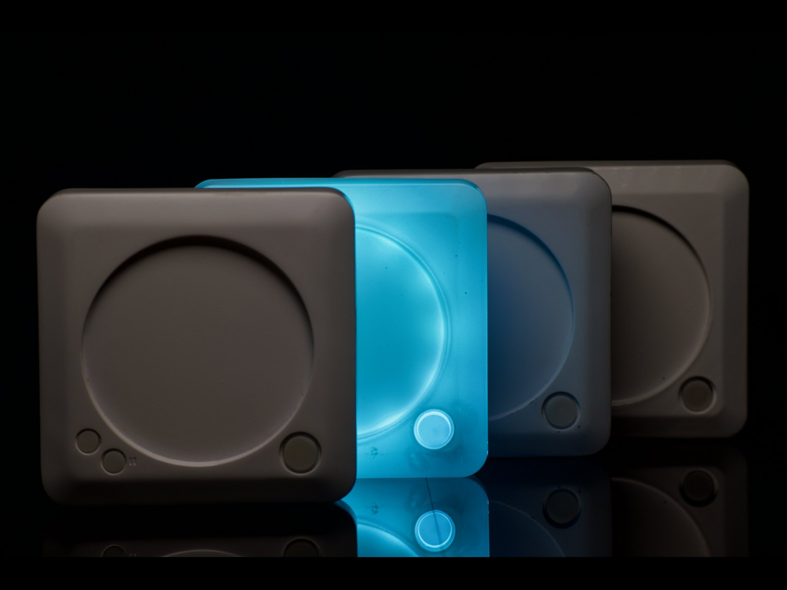 Four NexTurn coasters in a row, one lit blue. Each has a large turn button and two small buttons beside the cupholder.
